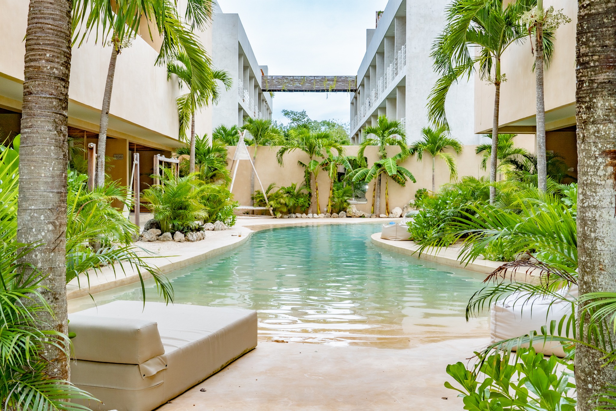 Palm-filled courtyard surrounding a curved turquoise pool