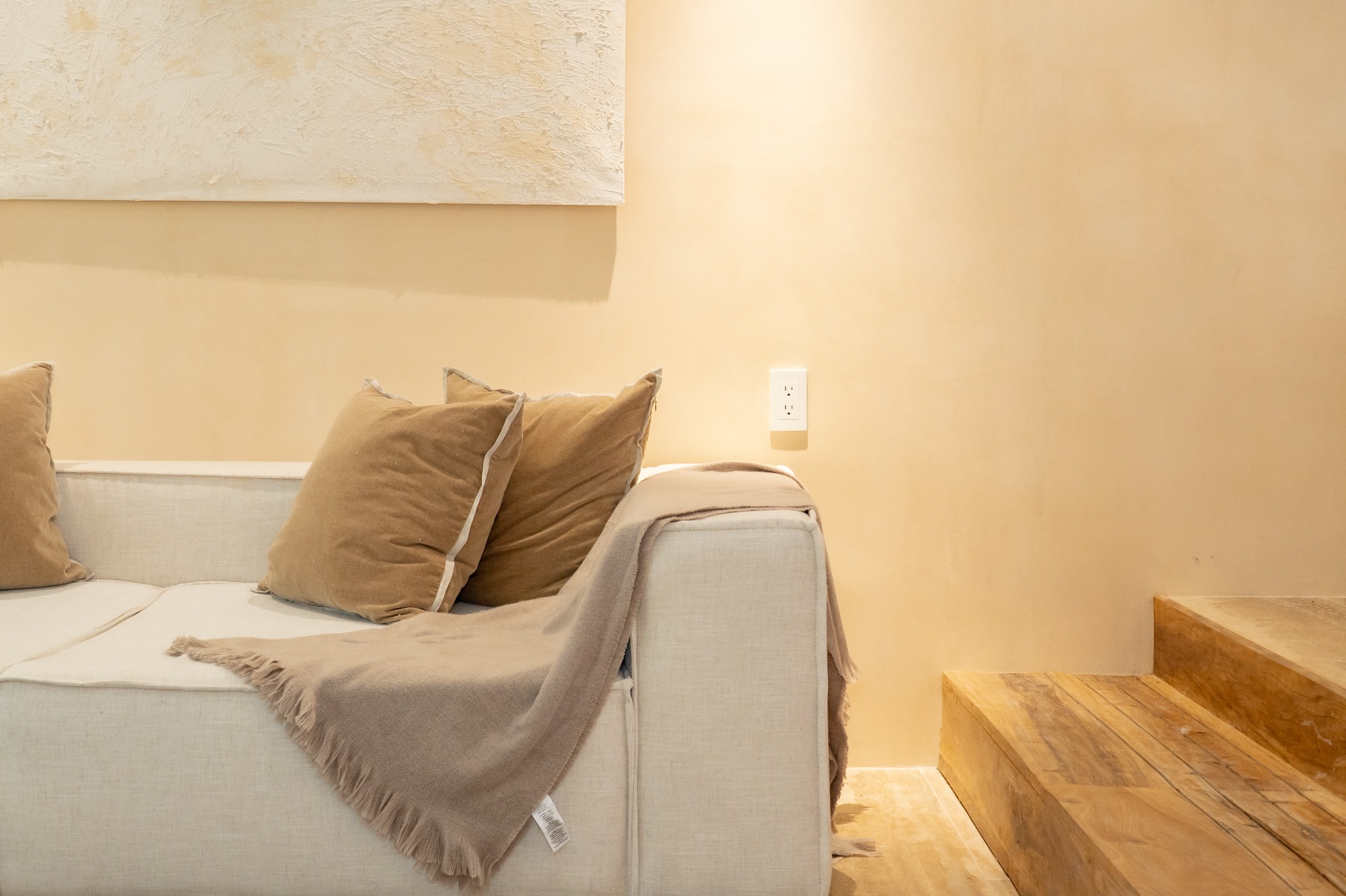 Natural linen sofa beside wooden steps
